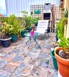 une terrasse avec une table, une chaise et des plantes en pot dans l'établissement Loft luminoso con terraza en Cangas Vigo, à Cangas