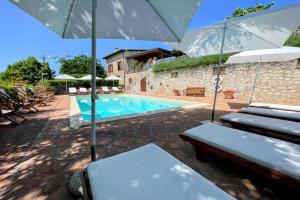 - une piscine avec des chaises et des parasols en face d'une maison dans l'établissement Spoleto Country Park - Slps 28, à Acquaiura