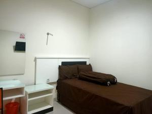 een slaapkamer met een bed en een witte muur bij OYO 93303 Lourdes Blessing Hill in Tomohon