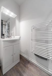 Baño blanco con lavabo y espejo en Residence Germot - Appartements design Centre Ville proche Thermes, en Vichy