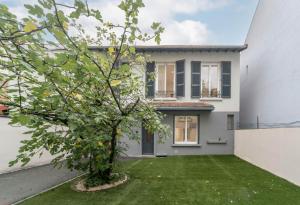 una casa blanca con un árbol en el patio en Residence Germot - Appartements design Centre Ville proche Thermes, en Vichy