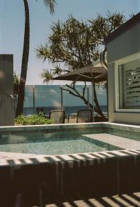 a swimming pool with a view of the ocean at 71 Hastings Street - Beachfront in Noosa Heads