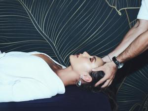 a woman in a white dress laying on a bed with her hands on her head at MAMAKA Bali in Kuta +90 photos