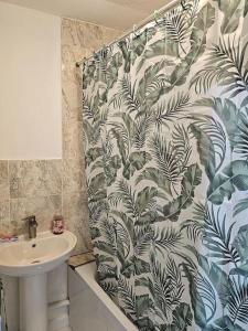 a bathroom with a sink and a shower curtain at London Serviced Accommodation E10 x DM 4 Weekly x Monthly Offers x Leyton x by D6ten Homes Ltd in London
