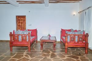 uma sala de estar com duas cadeiras vermelhas e uma mesa em Beach Way Villa em Malindi