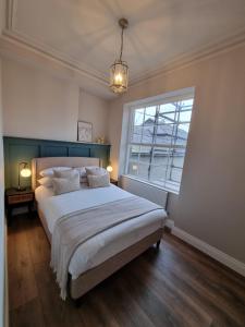 - une chambre avec un grand lit et une fenêtre dans l'établissement The Auction House, à Belfast