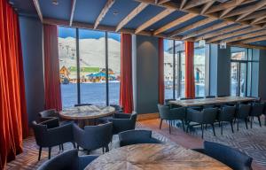 um restaurante com mesas e cadeiras e uma grande janela em New Gudauri Ski4Life em Gudauri