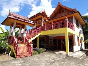 uma casa com uma varanda vermelha e amarela em Jasmin Resort em Mae Hong Son