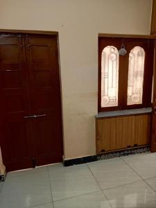 een lege kamer met twee deuren en een raam bij 1 BHK House with AC fully operational kitchen with wifi in Hyderabad