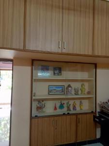 uma cozinha com armários de madeira e prateleiras com estatuetas em 1 BHK House with AC fully operational kitchen with wifi em Hyderabad