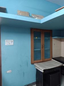 een kamer met een blauwe muur met een tafel en een kast bij 1 BHK House with AC fully operational kitchen with wifi in Hyderabad