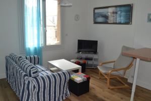 - un salon avec deux canapés et une télévision dans l'établissement Marguerite, à Saint-Malo