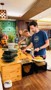 un grupo de personas de pie en una cocina preparando comida en Peaks And Pines Resort, en Lansdowne