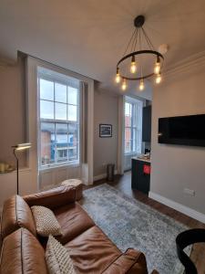 een woonkamer met een bank en een flatscreen-tv bij The Auction House in Belfast