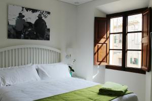 a bedroom with a bed with a green blanket on it at Marton Valldemossa Turismo de Interior in Valldemossa