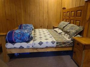 a bedroom with a wooden bed with pillows on it at Kashmir Star Guest House & Family Resort in Nārān
