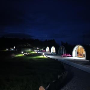 a night view of a street with domed buildings at Wheelhousepods glamping in Donegal