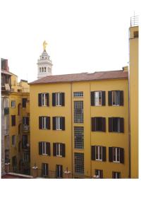 um edifício amarelo com uma torre de relógio ao fundo em Lexie Suites em Roma