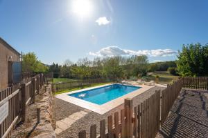 a swimming pool in a yard with a fence at Mas dels Frares in Vilafreser