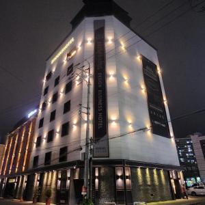um edifício branco alto com luzes acesas à noite em Brooks Business em Changwon