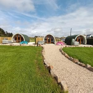 a gravel path in front of two domed buildings at Wheelhousepods glamping in Donegal