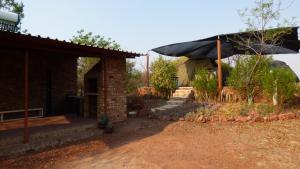 una casa de ladrillo con un porche y escaleras a ella en Hartbees Boskamp, en Dinokeng Game Reserve
