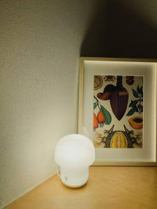 a white lamp on a table next to a picture at Private House in Mapo in Seoul