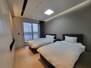 Postel nebo postele na pokoji v ubytování 쏘타스위트 속초 월드스테이트 + 37 fotografií