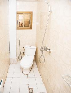La salle de bains est pourvue d'une douche et de toilettes. dans l'établissement Boston Residences Bonamoussadi, à Douala