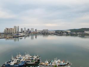un grupo de barcos están atracados en un puerto en World State Hotel Sokcho, en Sokcho