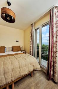 1 dormitorio con cama y ventana grande en Bastidon Golf de Pont Royal en Mallemort