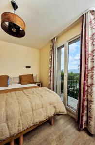 a bedroom with a bed and a large window at Bastidon Golf de Pont Royal in Mallemort