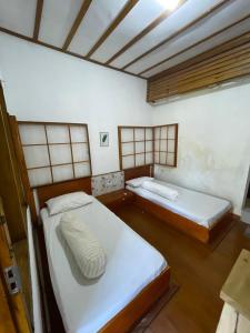 Wanci的住宿－Nua Indah Hotel & Resto Wakatobi，铺有木地板的客房内的两张床
