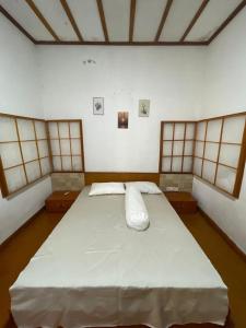 un grande letto bianco in una stanza con finestre di Nua Indah Hotel & Resto Wakatobi a Wanci