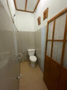 a small bathroom with a toilet and a shower at Nua Indah Hotel & Resto Wakatobi in Wanci