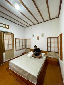 Wanci的住宿－Nua Indah Hotel & Resto Wakatobi，坐在房间里床边的人