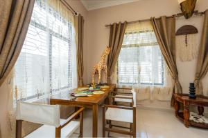 une salle à manger avec une statue de girafe sur une table en bois dans l'établissement Shivo Guest House, à Kiembi Samaki