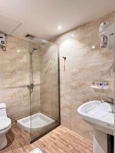 a bathroom with a shower and a toilet and a sink at Al Muhaidb Residence Al Maidan in Hafr Al Baten