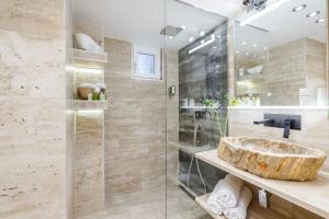 a bathroom with a sink and a glass shower at Stylish two-bedroom suite in the center in Budapest