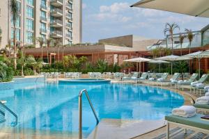 a large swimming pool with chairs and umbrellas at Four Seasons Hotel Cairo at Nile Plaza in Cairo