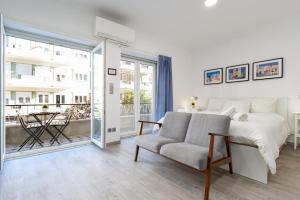 a bedroom with a bed and a chair and a window at AL d' Cacilhas Studio in Almada