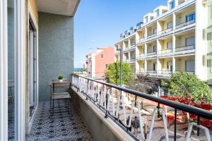 a balcony with a bench and some buildings at AL d' Cacilhas Studio in Almada