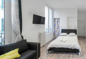 1 dormitorio con 1 cama y 1 sofá en Residence Germot - Appartements design Centre Ville proche Thermes, en Vichy