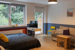 a bedroom with a bed and a couch and a tv at Central apartment with Terrace and a free parking in Duisburg