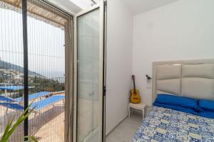 a bedroom with a bed and a balcony with a guitar at Casa Melevyen in Positano in Positano