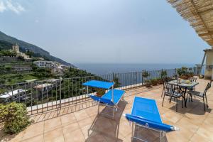a balcony with two blue chairs and a table at Casa Melevyen in Positano in Positano