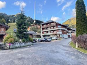 a street in a village with cars parked in front of a building at Dans résidence neuve LE SNOW ROC sur les pistes, grand studio cosy 5 pers avec terrasse panoramique, SAUNA, WIFI in Saint-Jean-dʼAulps