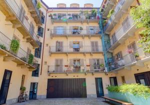 トリノにあるCasa Accademia: unica e centraleのバルコニーとガレージ付きのアパートメントビル