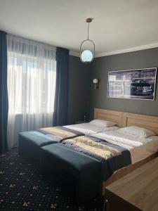 una camera da letto con due letti e una grande finestra di Autopapa a Rustavi
