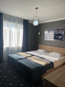 a bedroom with two beds and a large window at Autopapa in Rustavi